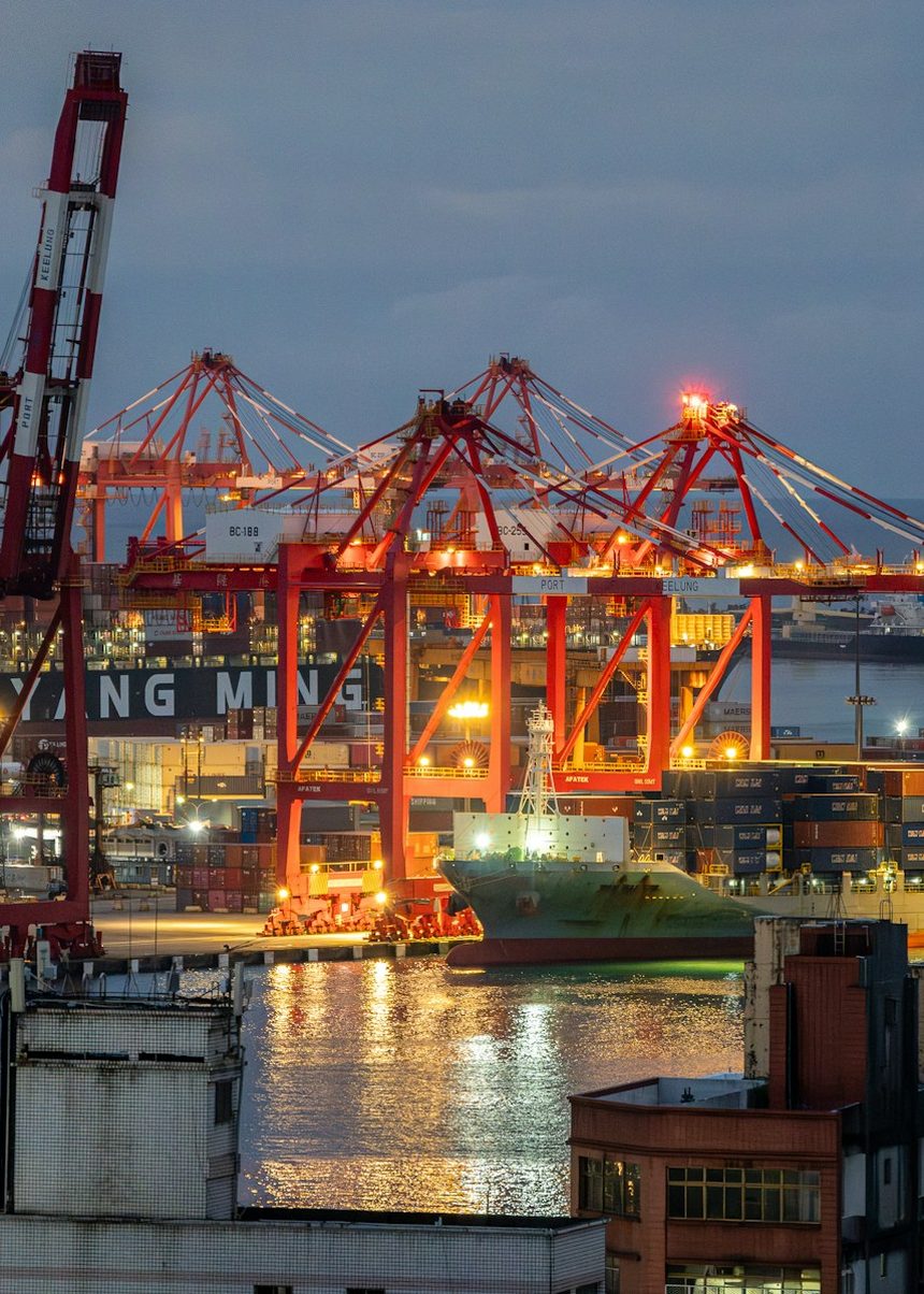 Terminal de contenedores al anochecer, con grúas pórtico operando.